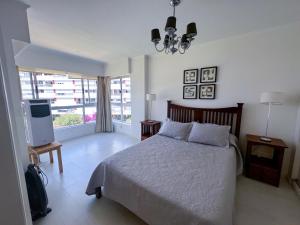 1 dormitorio con 1 cama y TV en Apartamento Torre Triangulo Mansa, en Punta del Este