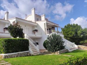 a large white house with stairs and bushes at Bella Brisa, Port d'Addaia in Port d'Addaia