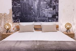 een slaapkamer met een groot wit bed met 2 lampen bij PASSAGE - historic boutique suite in Haarlem