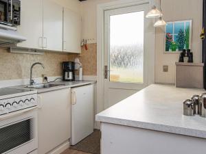 a kitchen with white cabinets and a sink and a window at 6 person holiday home in Lemvig in Trans