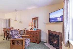 a living room with a fireplace and a flat screen tv at Slopeside Ski-In/Ski-Out ; HotTub ; 2 Room 2 Bath in Hunter