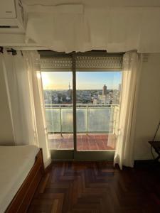 een kamer met een groot raam met uitzicht op de stad bij E N Alquileres Temporarios Dpto en el centro con excelente vista in Concordia