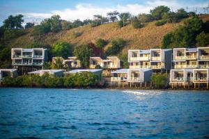 una fila de casas en la orilla de un cuerpo de agua en Loloata Island Resort, en Loloata Island