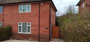 a red brick house with a door and a fence at Stunning 3 bed House sleeps 5-6, WiFi, OFF Street Parking in Nottingham close to M1 in Nottingham