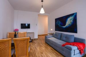 sala de estar con sofá azul y TV en Villa Angela, en Orebić
