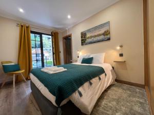 a bedroom with a bed with a green comforter at Briola by AnaLodges in São Vicente