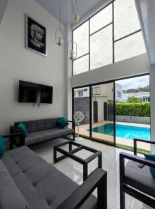 a living room with a couch and a tv and a pool at Lujosa Mansión Privada estilo mediterráneo in Melgar
