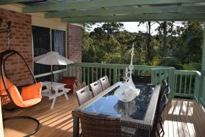 un patio con mesa y sillas en una terraza en LILLI PILLI SUBLIME at the Beach - Family & Dog Friendly, en Batemans Bay