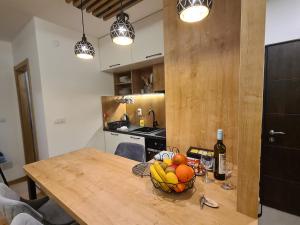 uma cozinha com uma mesa de madeira e uma taça de fruta em VilaJahor Natasa A11 em Jahorina