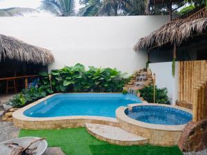 una piscina en un patio trasero con un complejo en Tres Palmas en Montañita