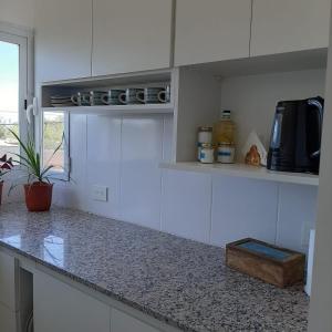 cocina con armarios blancos y encimera en LC 1706 - Dpto. zona Costa del Limay en Neuquén