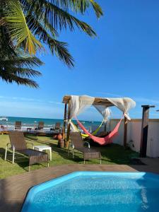- une piscine avec des chaises et un hamac, ainsi qu'une plage dans l'établissement Pousada Grandmar, Maragogi, à Maragogi