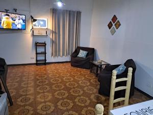 sala de estar con TV y silla en La colonial en Mendoza