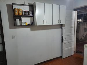 cocina con armarios blancos y nevera en La colonial en Mendoza
