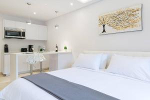 een witte slaapkamer met een bed en een keuken bij HIGHLINE 101 By SANDY POWERFUL in Tulum +10 foto's