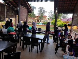 a group of people sitting at tables in a restaurant at Seri Indah Resort in Kuala Terengganu