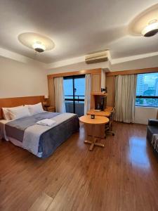1 dormitorio con cama, mesa y sofá en Hotel na Alameda Lorena - Jardins, en São Paulo