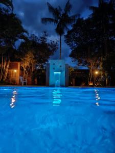 una piscina por la noche con un edificio en el fondo en Pousada Barcelos en São Roque de Minas