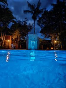 a swimming pool at night with a building in the background at Pousada Barcelos in São Roque de Minas