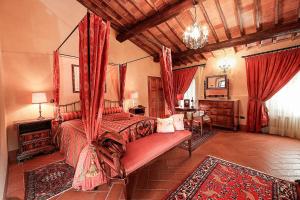 a bedroom with a canopy bed and a table at Castello Di Tornano Wine Relais in Gaiole in Chianti