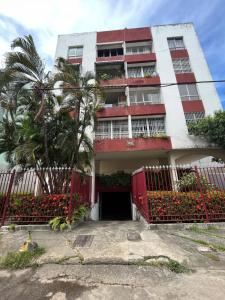 budynek z czerwoną bramą i palmą w obiekcie Apartamento 5min da praia no Rio Vermelho w mieście Salvador