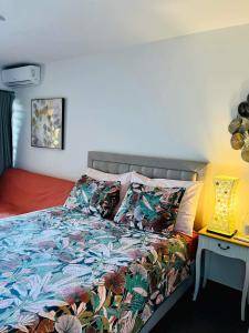 um quarto com uma cama com um edredão colorido em Tehautahi Cozy Lodge em Papeete