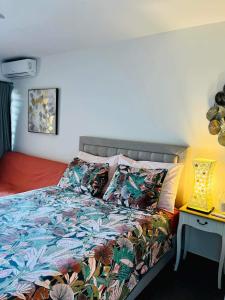 - une chambre avec un lit et une couette colorée dans l'établissement Tehautahi Cozy Lodge, à Papeete