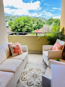 balcón con sofás y vistas a la ciudad en Tehautahi Cozy Lodge, en Papeete