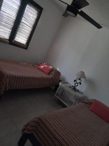 een slaapkamer met 2 bedden en een plafondventilator bij La Angelita in San Andrés de Giles