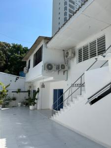um edifício branco com escadas ao lado de um edifício em Private room MH102 close to old city em Cartagena das Índias