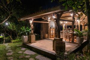 a house with a deck at night with lights at Umah Capung Sebatu Villas in Tegalalang