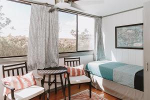 a bedroom with a bed and a table and chairs at Holualoa Gardens 101 in Kailua-Kona