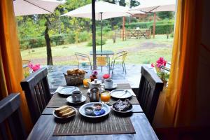 una mesa de madera con comida y una sombrilla en Posada Inguz en Villa Berna