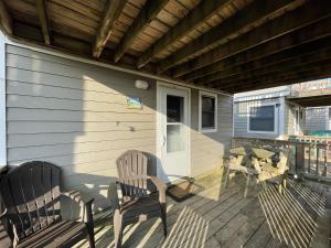 a porch with two chairs and a table and a picnic table at NC 12 56821-15 Condo in Hatteras