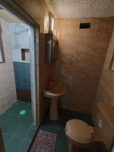 a small bathroom with a toilet and a sink at Casa Azul Aragon in Mexico City