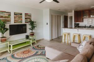 a living room with a couch and a kitchen at Holualoa Garden 103 in Kailua-Kona