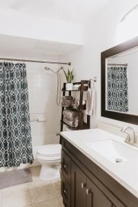 een badkamer met een wastafel, een toilet en een spiegel bij Holualoa Garden 103 in Kailua-Kona