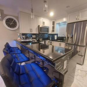 una cocina con encimera y sillas azules. en Beautiful Bright 3 Bed Townhouse, en Vancouver