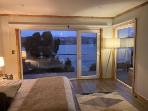 1 dormitorio con ventana grande con vistas al lago en Lago Vichuquen en Vichuquén