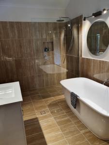 a bathroom with a tub and a sink and a mirror at The Paddocks in Maleny