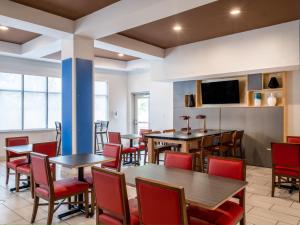 una sala da pranzo con tavoli e sedie rosse di Holiday Inn Express Hotel & Suites Beaumont Northwest by IHG a Beaumont