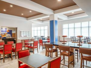 una sala da pranzo con tavoli, sedie e finestre di Holiday Inn Express Hotel & Suites Beaumont Northwest by IHG a Beaumont