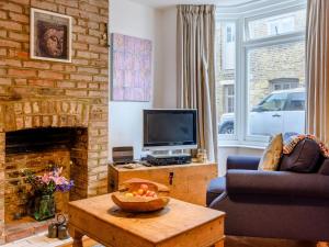 a living room with a fireplace and a television at Anchor Cottage in Whitstable