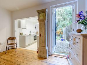 a kitchen with a grandfather clock in the middle of a room at Anchor Cottage in Whitstable