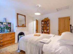 um quarto com uma grande cama branca com toalhas em Anchor Cottage em Whitstable