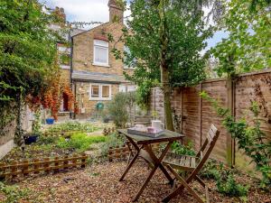 a small garden with a table and a fence at Anchor Cottage in Whitstable