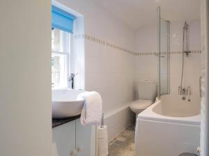 uma casa de banho branca com um lavatório e um WC em Dorothy Forster Court em Alnwick