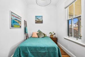 Un dormitorio con una cama con una manta verde. en Saltbush Cottage in fabulous South Fremantle, en South Fremantle