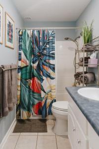 a bathroom with a toilet and a shower curtain at Holualoa Garden 303 in Kailua-Kona