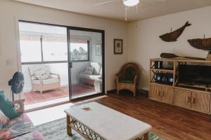 a living room with a couch and a tv at Holualoa Garden 303 in Kailua-Kona